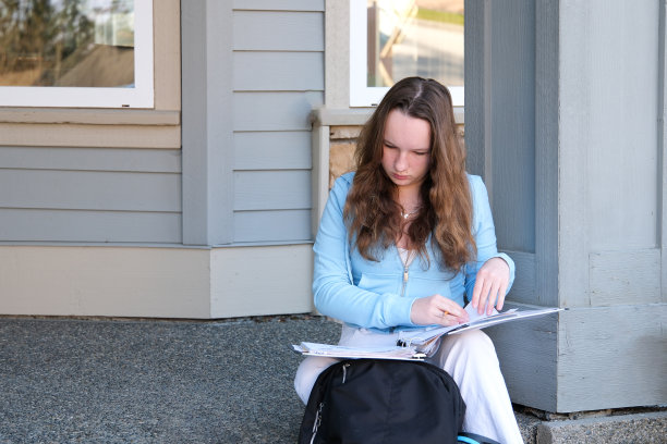 十几岁的女孩带着文件夹和背包在户外做作业，在笔记本上翻页，寻找数据交流，热爱学习，准备考试忘记钥匙，坐在门口图片下载