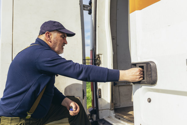 成熟的货车司机进入他的送货车检查货物。图片下载