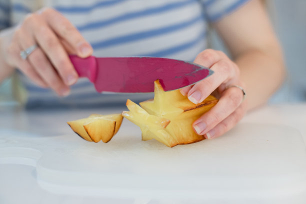 小女孩正在切杨桃/杨桃果实图片下载