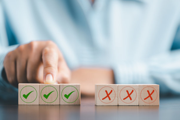 立方体木块上正确或错误标记的概念。商业和生活理念。思考是或否的选择，困难情况下的商业选择，木头上有正确或错误的标记。图片下载