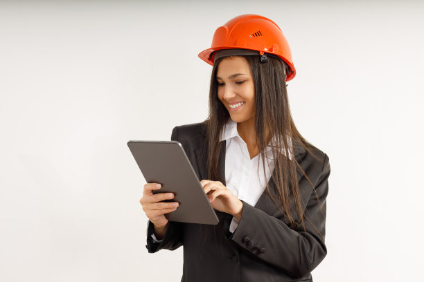 拿着平板电脑和防护头盔的年轻女子。图片下载