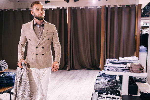帅气的年轻人在店里买西装图片下载