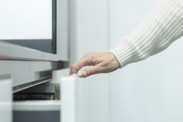 有组织的餐具抽屉:女人的手拉开厨房橱柜图片下载