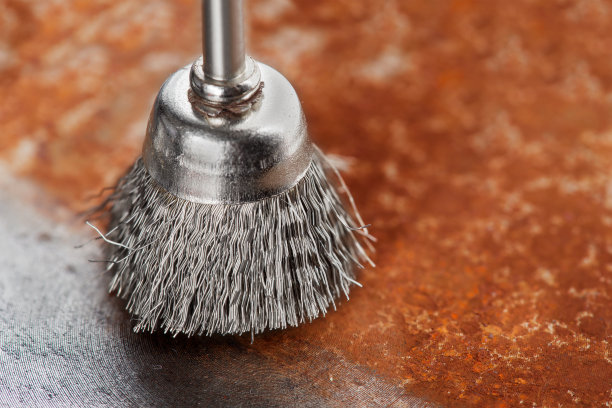 钻头用钢刷清除带锈的旧金属片图片下载