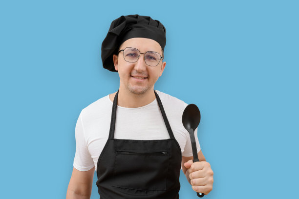 一个厨师的肖像，系着围裙，手里拿着勺子，在蓝色的背景下看着相机。图片下载