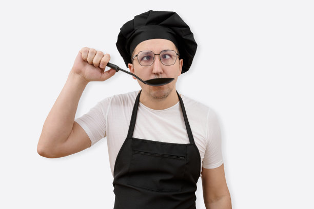 情绪化的厨师用勺子在白色背景上品尝食物。烹饪与人的概念图片下载