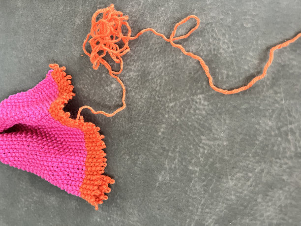 照片色彩缤纷的粉红色和橙色的针织部分解开纹理灰色背景图片下载