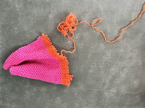 照片色彩缤纷的粉红色和橙色的针织部分解开纹理灰色背景图片下载