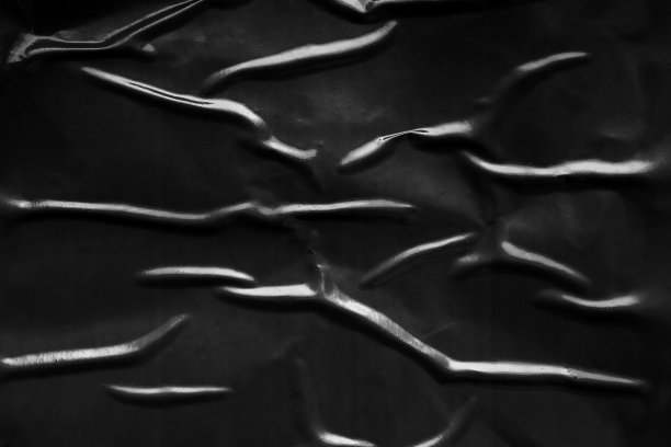 黑色褶皱和折痕塑料海报纹理背景图片下载