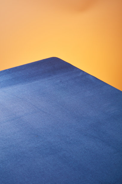 餐桌与蓝色皮革桌布在橙黄色的背景图片下载