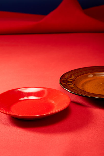 红色的皮底布下面放着一个红色的餐盘图片下载