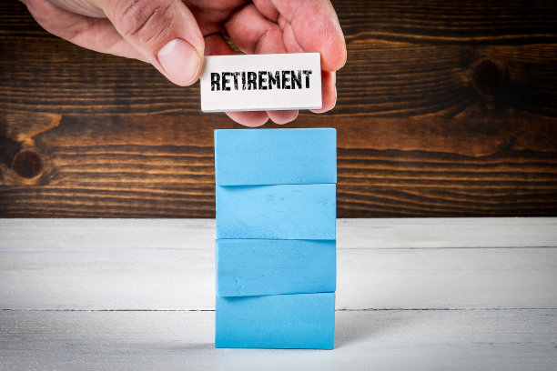 退休的概念。五颜六色的积木堆在一个涂木纹背景图片下载