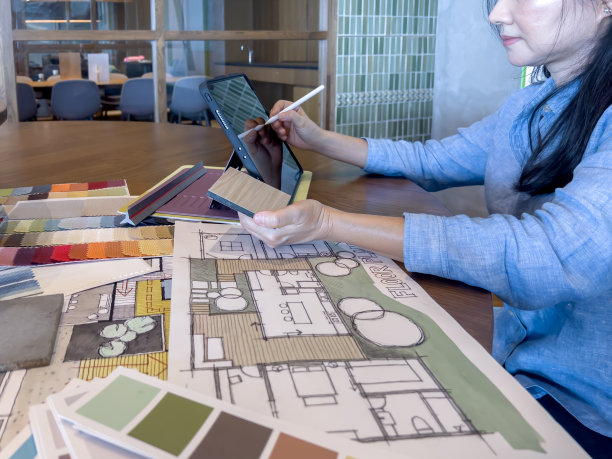 一位女设计师在设计工作室与智能设备和材料样品一起工作。图片下载