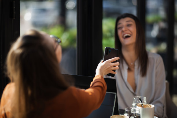 两个年轻的女商人在咖啡馆里进行一对一的会谈。下班后，朋友们在靠窗的桌子旁聊着八卦，喝着咖啡，思考着……图片下载
