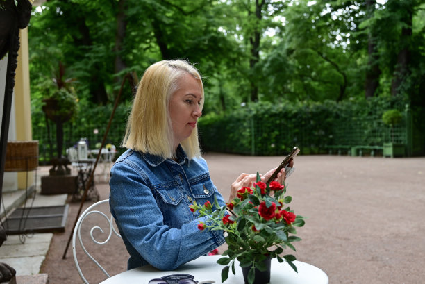 一个女孩在公园里自拍。一位时尚女孩用智能手机自拍图片下载