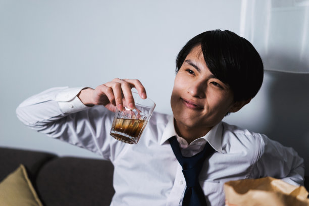 由于工作压力大，30多岁的人在回家后还可以单手喝一杯威士忌图片下载
