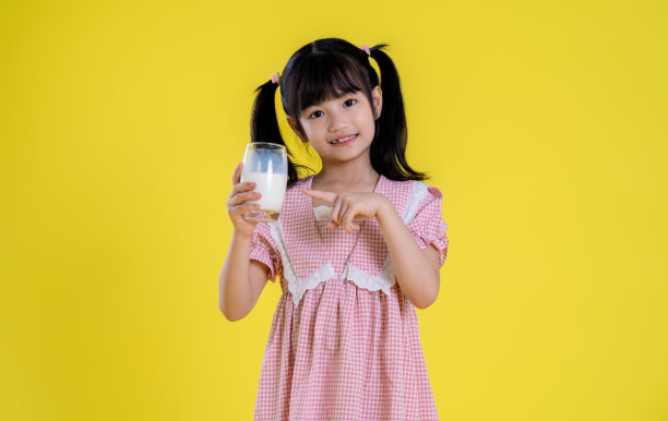 亚洲小女孩在黄色背景上摆姿势图片下载