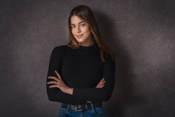 黑暗背景下自信的年轻女子特写图片下载