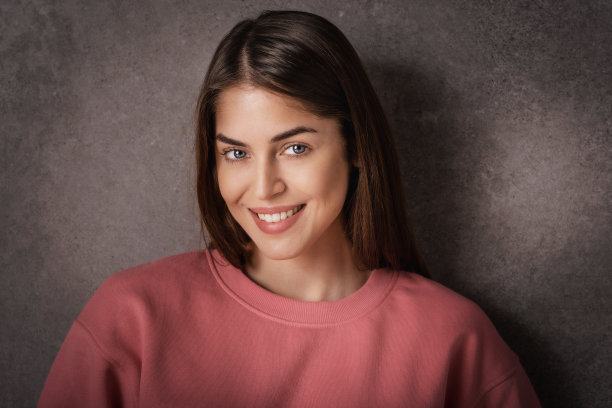 黑暗背景下自信的年轻女子特写图片下载