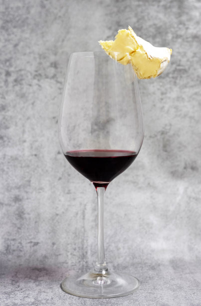 葡萄酒装在玻璃杯或瓶子里，与奶酪、核桃、软木塞和开瓶器一起放在厨房毛巾上。瓶子倒了。软木支撑玻璃图片下载