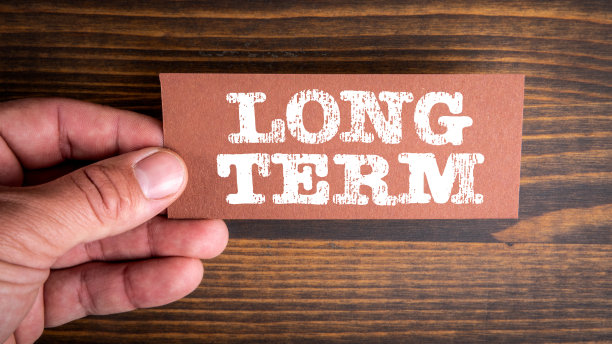 长期的。一个男人手里拿着一张写着文字的纸图片下载