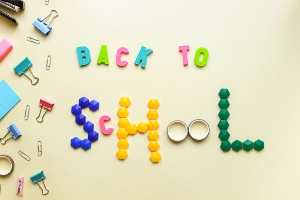 黄色背景和信纸上平铺着“回校”字样图片下载