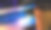 在黑暗中半闭着的笔记本电脑和一杯咖啡发出五彩的光芒。图片下载