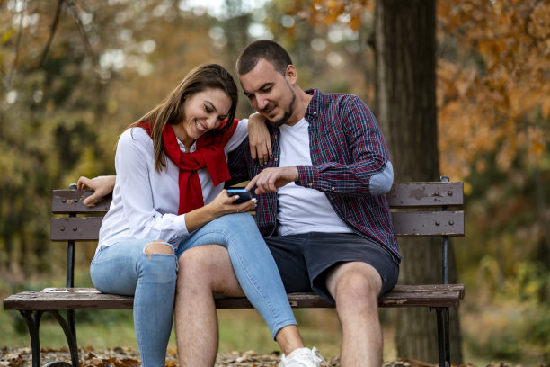 一对相爱的情侣看着用手机拍下的照片。图片下载
