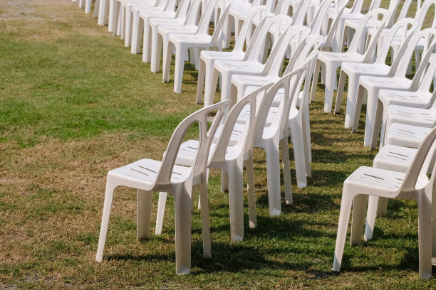 白色塑料椅子在庆祝活动和户外活动的花园。图片下载