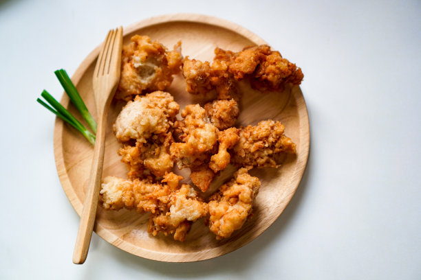 一张俯视图照片显示，一个即食盘子里排列着酥脆的黄色鸡肉。图片下载