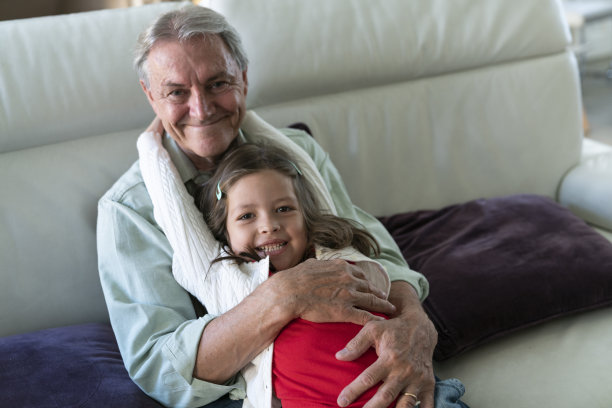 老人和孙女坐在家里沙发上的照片图片下载