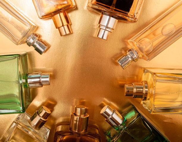 俯视图，一组香水瓶在彩色背景上的平面布局。图片下载