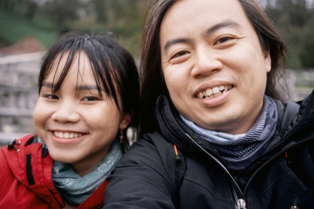 幸福的亚洲夫妇穿着红黑夹克自拍图片下载