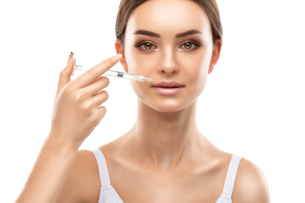 美容师给美女注射丰唇和鼻唇褶皱抗皱。美容院的女性美容。图片下载