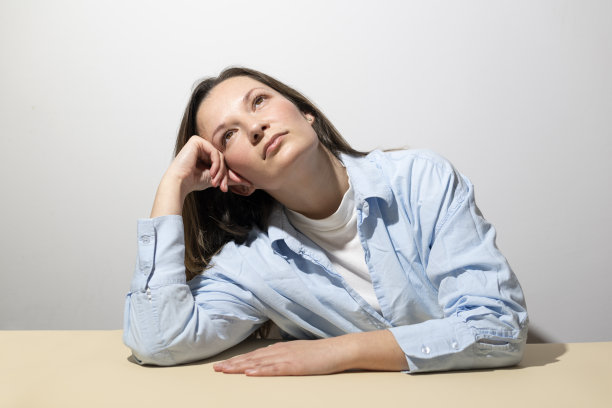 一个随意的漂亮的年轻女孩的肖像，在白色的背景上思考着一些孤立的东西图片下载