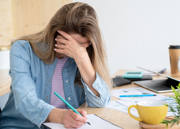 一个有思想的女人在做创造性的工作时喝了很多咖啡图片下载