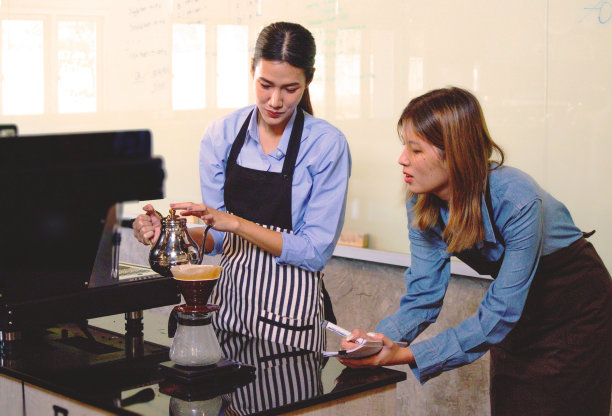 一位经验丰富的穿制服的女咖啡师将示范如何制作咖啡，并提供大师课程。小企业和咖啡馆老板的概念图片下载