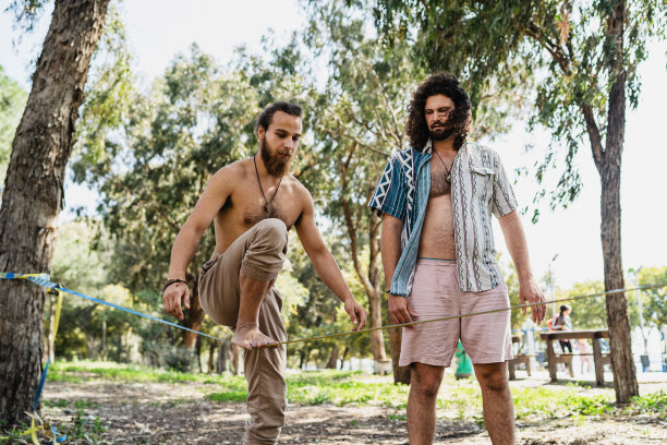 夏日里，两名男子在城市公园里滑滑梯图片下载