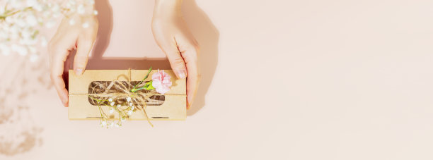 节日横幅与女性手拿礼盒粉红色的背景图片下载