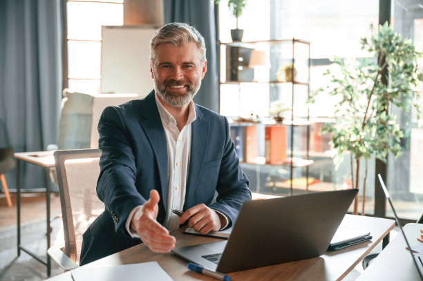 微笑，握手，问候。老年商人正在办公室工作图片下载