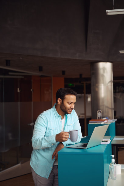 男主一边喝茶一边看着笔记本电脑图片下载