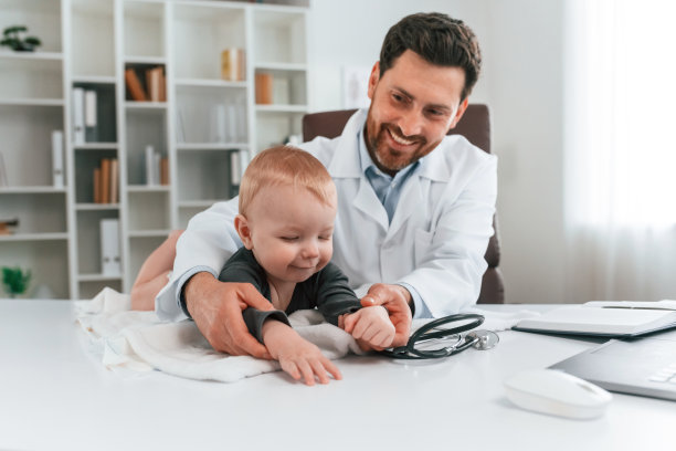 孩子躺在桌子上。带着小孩的医生正在柜子里工作图片下载