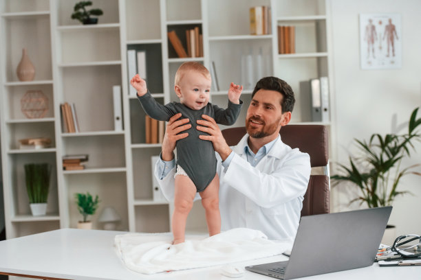 手里抱着男孩。带着小孩的医生正在柜子里工作图片下载