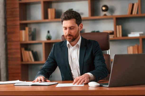 穿着正装的商人正在室内工作图片下载