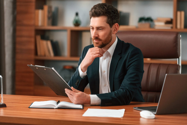 处理文档。穿着正装的商人在室内图片下载