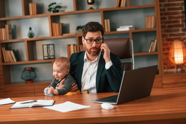 忙碌的父亲。穿着正装的商人正在室内工作。与孩子图片下载