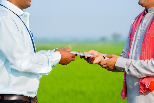 农村农民在绿色农田接受银行贷款的特写镜头——农业企业贷款、金融援助和投资的概念图片下载