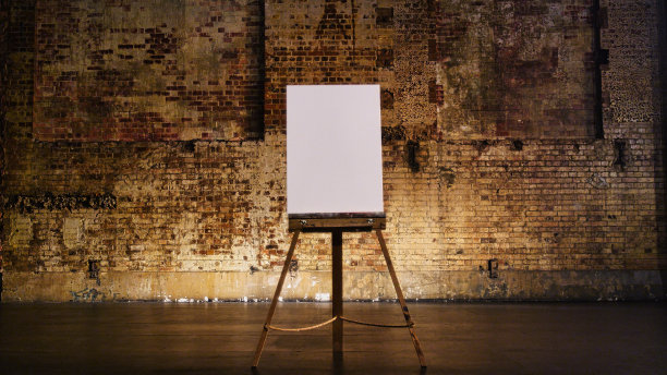 在剧院舞台上，质朴的砖墙前的画架上放着一幅空白画布图片下载