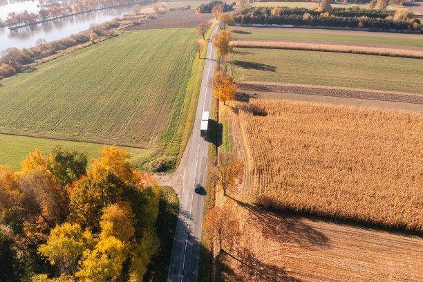 卡车在秋天上路。汽车运输。灰色半挂车卡车。秋天，运输卡车在湖边行驶。图片下载