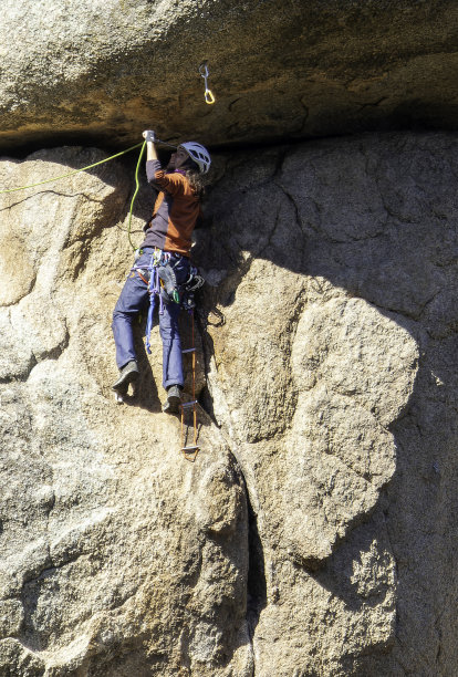年轻人在马德里的托雷洛多内斯攀爬花岗岩。攀岩。极限运动概念图片下载